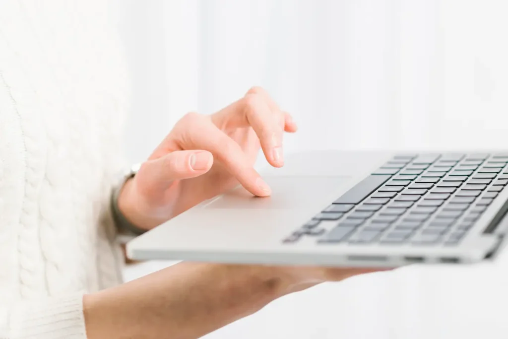 crop-hands-using-laptop-near-window